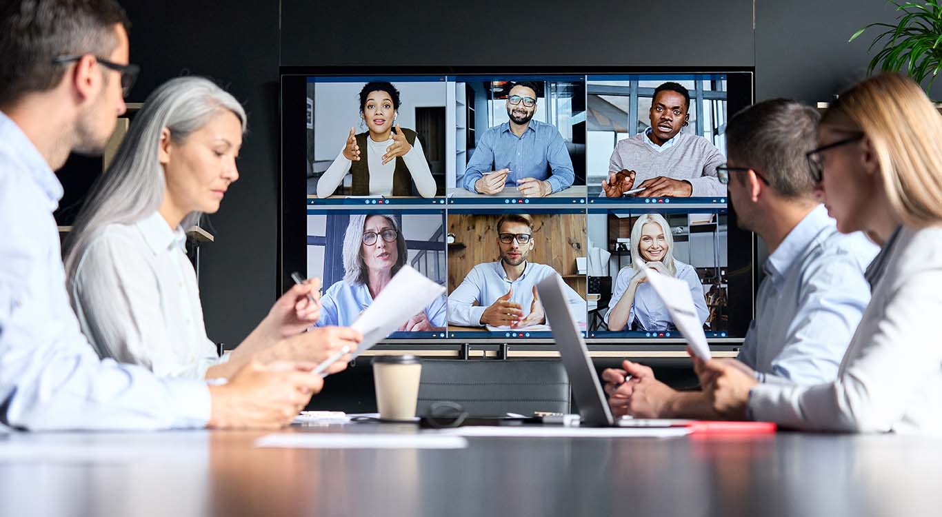 videochiamata aziendale globale in sala riunioni con diverse persone multietniche